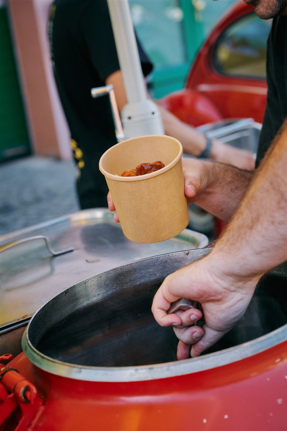 Roter Heisse-Räder-Transit mit Menütafel und Gästen beim Oldtimertreffen